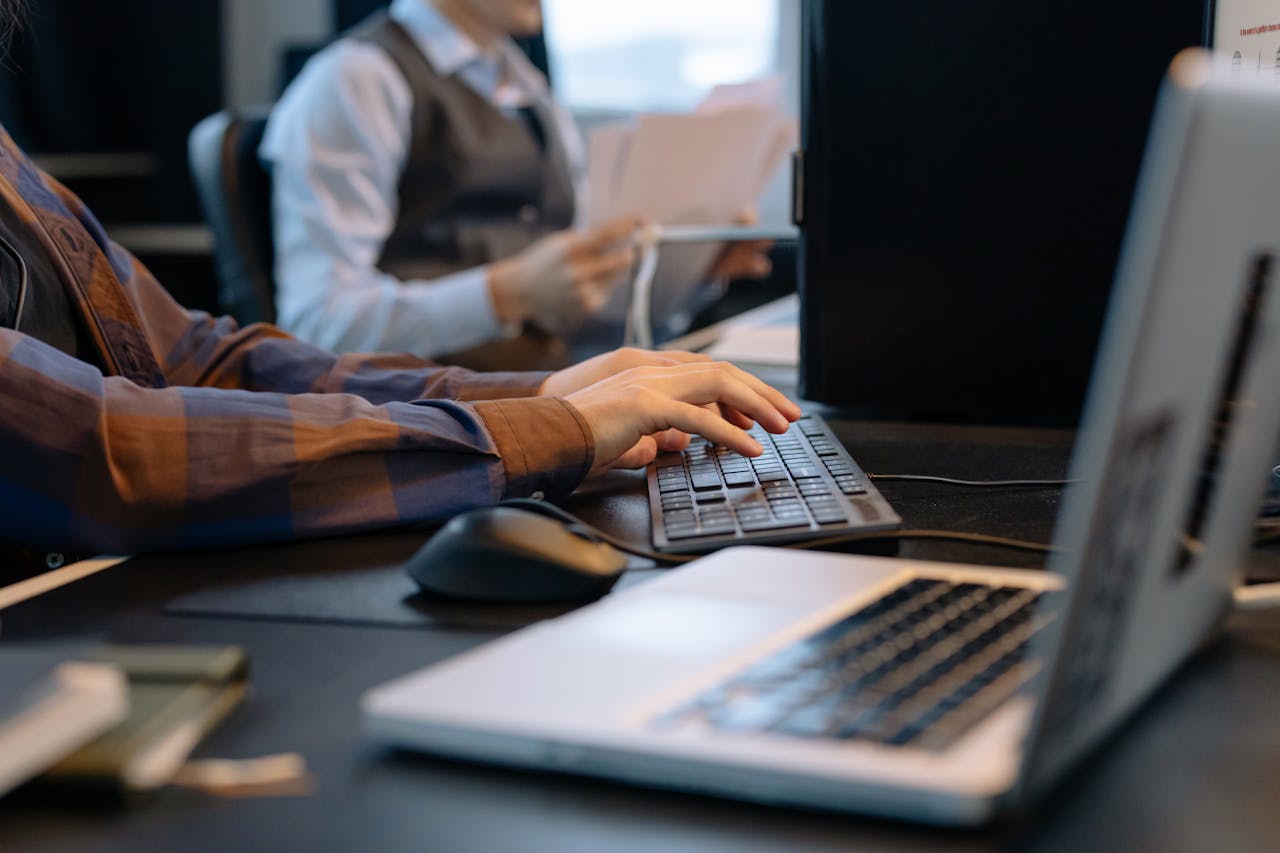 get-in-touch Close-up of office workers engaged in a tech project at a modern workplace.